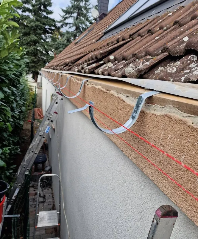 Rinnenhalter an der Traufe, ausgerichtet an einer gespannten roten Schnur